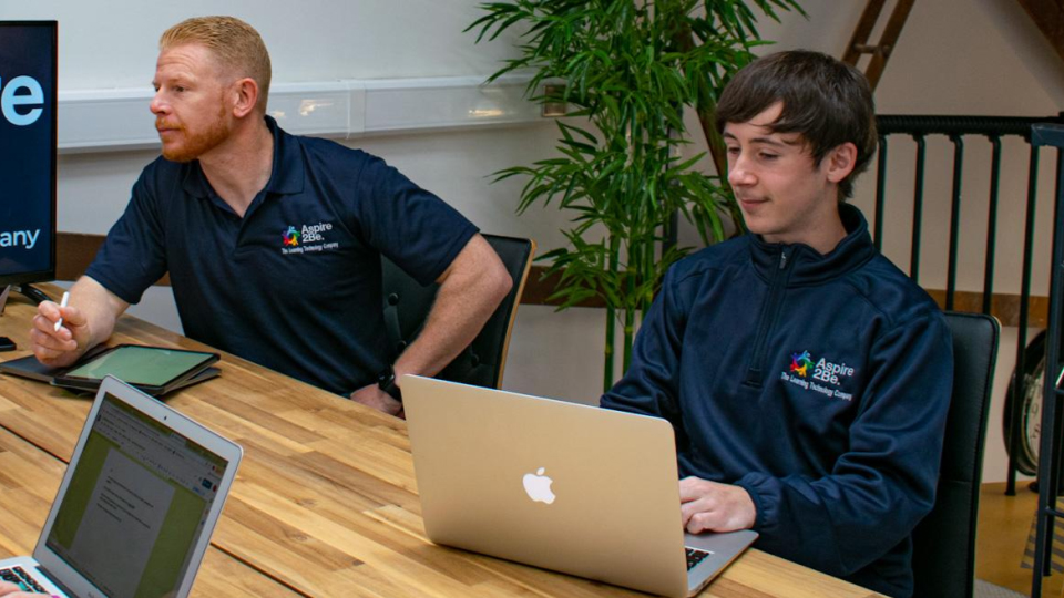 Two employees working together at desk