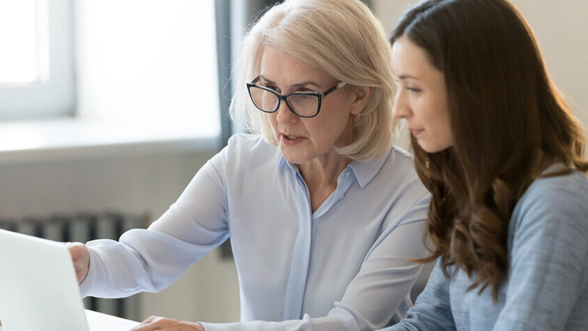 Two women sat at a computer screen
