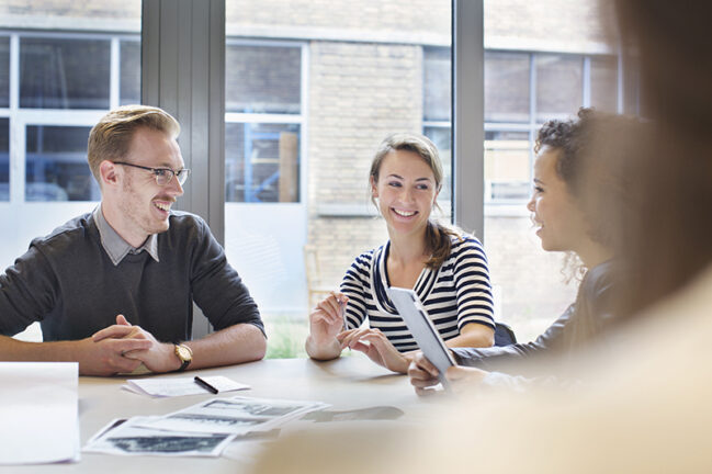 Design team meeting at conference table in creative office