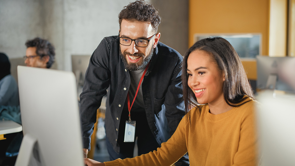 Teacher supporting a student sat at a computer