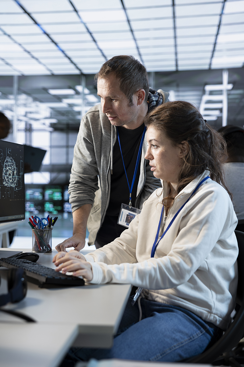 Male and female software developers sat at a computer