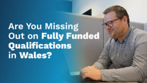 Man sat at desk with text overlaid reading "Are you missing out on fully funded qualifications in Wales"
